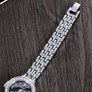 Detailansicht des silbernen Gliederarmbands und der Strass-Lünette einer Quarzuhr