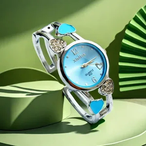 Dettaglio di un orologio da donna a bracciale con motivi a cuore e quadrante blu.