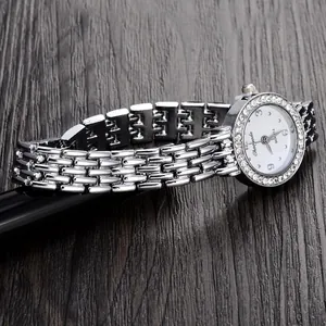 Detailansicht einer silbernen Damen-Quarzuhr mit einem kleinen, mit Strass besetzten Zifferblatt.
