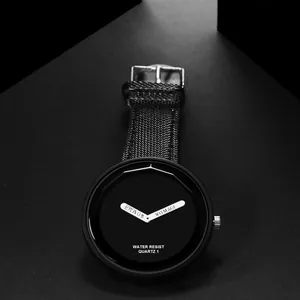 Primo piano di un orologio al quarzo nero minimalista con cinturino in tessuto nero
