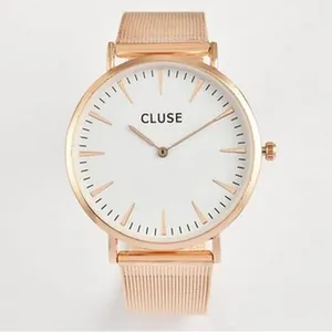 Dettaglio di un orologio minimalista in oro rosa con quadrante bianco