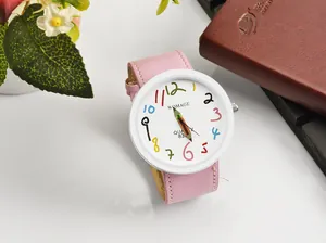 Dettaglio del quadrante WOMAGE con numeri colorati e lancette creative a matita.