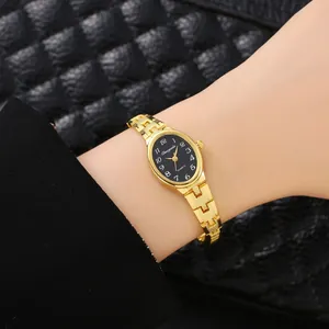 Primo piano di un elegante orologio a bracciale dorato con quadrante nero ovale al polso.