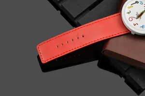 Dettaglio di un cinturino in pelle rossa e quadrante bianco con numeri colorati