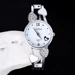 Primo piano di orologio da donna a bracciale argento con strass e ciondoli a cuore