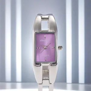 Vista macro di un orologio a bracciale argento rettangolare con quadrante viola vivace.