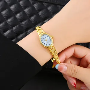 Elegante primo piano di un orologio da donna a bracciale dorato con quadrante blu ovale al polso