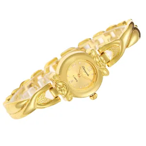 Gros plan d'une montre à quartz dorée avec un bracelet croisé floral élégant