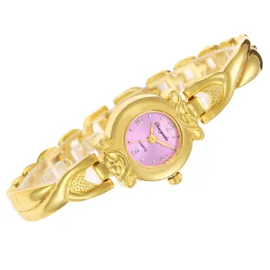 Détail d'une montre à quartz élégante avec bracelet croisé doré et cadran rose raffiné
