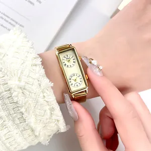 Elegant vintage gold rectangular dual time zone watch featuring a mesh strap on a wrist
