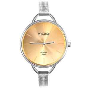 Primo piano di un elegante orologio da donna con quadrante dorato e cinturino in maglia