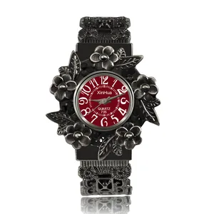 Nahaufnahme der XinHua Vintage-Armbanduhr mit Blumenschnitzerei und auffälligem rotem Zifferblatt