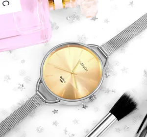Dettaglio orologio da donna con quadrante dorato e cinturino in maglia