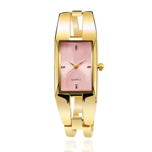 Primo piano di un orologio a bracciale dorato da donna con quadrante rosa.