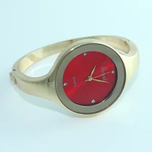 Dettaglio dell'orologio da polso a quarzo da donna dorato con quadrante rosso vivace