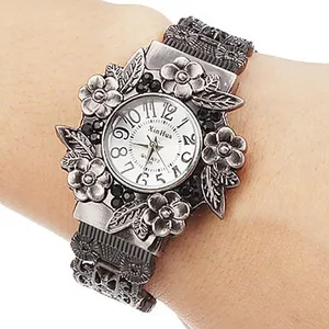 Makrodetail einer silberfarbenen Damenuhr mit Blumenmuster im Vintage-Stil und Quarzwerk