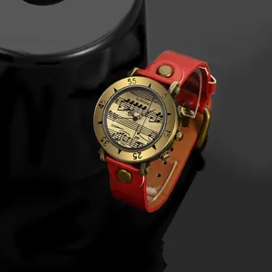 Dettaglio dell'orologio WoMaGe con quadrante a note musicali e cinturino rosso