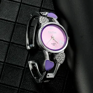 Primo piano di un elegante orologio da donna a forma di cuore con quadrante rosa