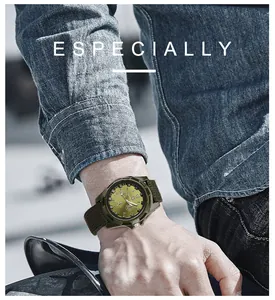 Detailed close-up view of a military green canvas watch worn with a denim shirt