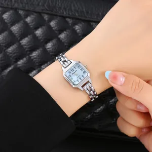 Primo piano di un elegante orologio a catena rettangolare d'argento al polso.