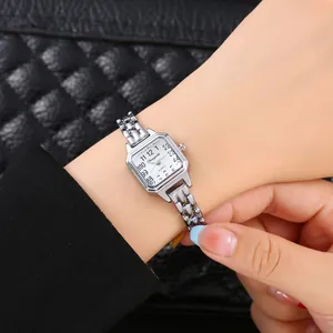 Dettaglio di un piccolo orologio da polso quadrato in argento al quarzo da donna.