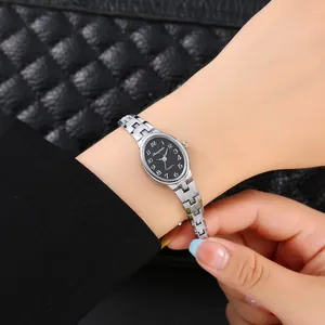 Elegante orologio a bracciale ovale argento con quadrante nero indossato sul polso