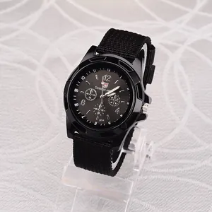 Detail view of men's sports watch with black canvas strap and military dial
