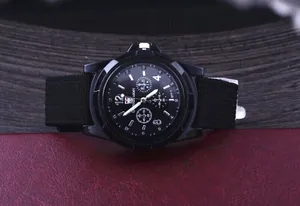 Close-up detail of the black military style dial and canvas strap of the sports watch