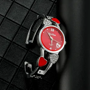 Dettaglio di un orologio a bracciale da donna a forma di cuore con quadrante rosso