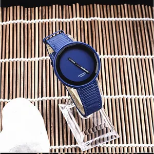Primo piano di un orologio al quarzo blu minimalista con cinturino intrecciato e grande quadrante