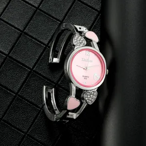 Dettaglio dell'orologio rigido argento con cuori, quadrante rosa e cristalli lucidi
