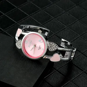 Dettaglio dell'orologio da donna con quadrante rosa e cinturino a cuore con strass