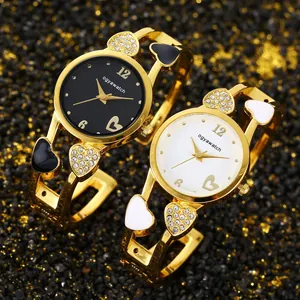 Vista dettagliata di orologi a bracciale a cuore dorati con quadranti bianco e nero