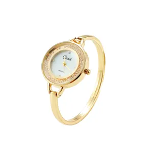Elegante reloj de brazalete dorado con bisel de cristales y esfera blanca detallada.