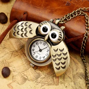 Nahaufnahme einer Vintage-Eulen-Taschenuhr aus Bronze auf einem antiken Landkartenhintergrund