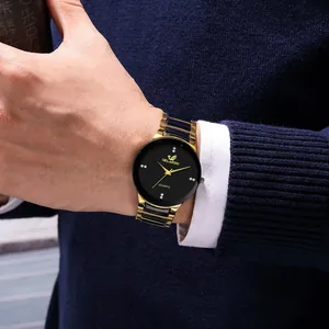 Primo piano di un elegante orologio al quarzo nero e oro con cinturino in acciaio al polso