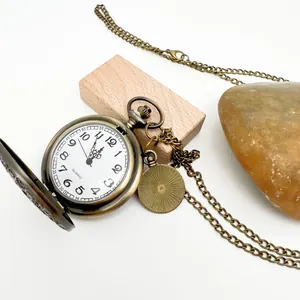 Detailansicht einer antiken Bronze-Quarztaschenuhr mit verzierten Zeigern und Kette.