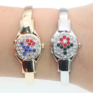 Close-up of two elegant rhinestone-encrusted flip-cover bangle watches worn on a wrist