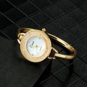 Primer plano de un elegante reloj de pulsera dorado con un bisel incrustado de cristales