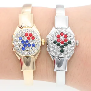 Close-up of gold and silver rhinestone bangle watches with flip covers