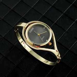Vista detallada del reloj tipo brazalete dorado de CUSSI con esfera negra.