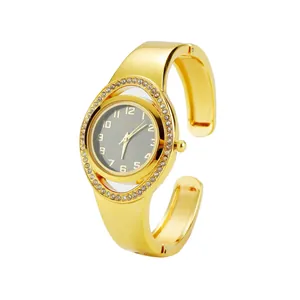 Dettaglio dell'orologio rigido da donna in oro con lunetta di cristalli e quadrante grigio
