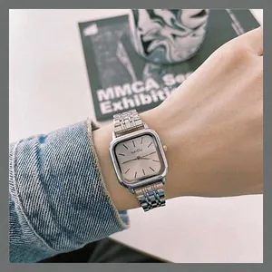 Gros plan d'une montre carrée argentée avec bracelet en acier élégant