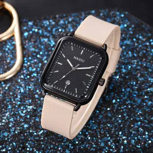 Primo piano di un orologio al quarzo rettangolare con cinturino in silicone beige e quadrante nero
