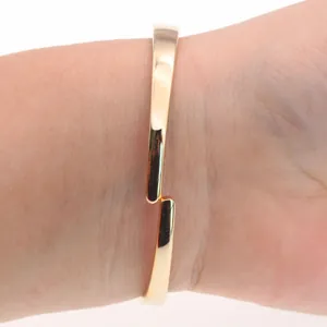 Detailed close-up of a stylish gold flip-cover bangle watch for women worn on the wrist