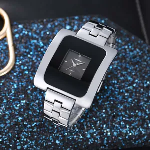 Primo piano di un elegante orologio quadrato argento con quadrante nero su glitter blu