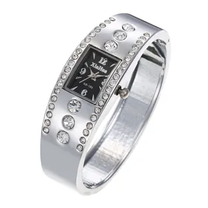 Primer plano de un elegante reloj de pulsera plateado con esfera negra y cristales