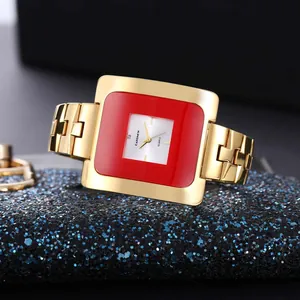 Primo piano di un orologio quadrato dorato CANSNOW vintage con una lunetta rossa vivace