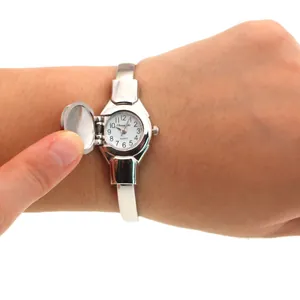 Detail view of a lady's silver bangle watch showing the openable flip cover lid.