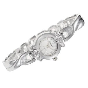 Détail d'une montre à quartz argentée pour femme avec bracelet décoratif croisé chic